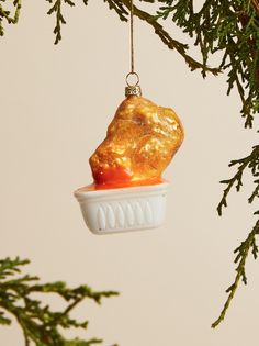 a christmas ornament hanging from a tree with a piece of food in it