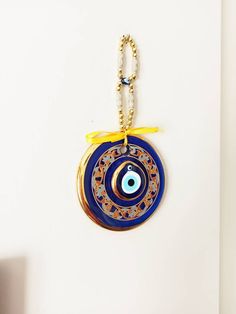 ⭐️Diameter of the blue evil eye bead is 14 cm(5.5 in) ⭐️Height of the blue eye wall charm is 28 cm(11 in) ⭐️Evil eye hanging is gold plated. There are two blue glass beads on the hanging. ⭐️Evil eye bead is painted. ⭐️ Evil Eye is totally handmade. ⭐️The evil eye bead is large and it is perfect for home decoration. ⭐️Turkish eye decor is also gold plated. It is believed that evil eye charm protects you from the evil eyes. Evil eye charm is over 5000 years old. It is found in all major religions Bohemian Blue Evil Eye Bracelet For Festival, Handmade Bohemian Blue Evil Eye Bracelet, Handmade Blue Bohemian Evil Eye Bracelet, Handmade Blue Jewelry For Blessing, Handmade Blue Evil Eye Bracelet For Festival, Blue Evil Eye Bracelet With Round Beads For Festivals, Traditional Blue Evil Eye Jewelry, Handmade Blue Evil Eye Bracelet For Good Luck, Blue Evil Eye Bracelet For Festivals