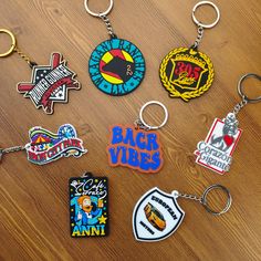 many different key chains on a table with one being used as a logo for the band