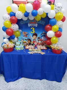 the birthday party table is decorated with balloons