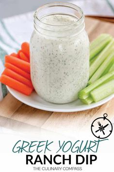 a white plate topped with carrots and celery next to a jar of greek yogurt ranch dip