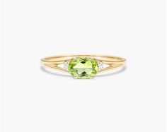 14K Yellow Gold Oval Peridot and Diamond Accent Birthstone Ring. The birthstone of August, peridot is known for its distinctive light green color and is said to bring strength, joy, prosperity, and good health to those who wear it. It is also known to bring harmony to romantic relationships and protect against evil, jealousy and even bad dreams. This delicate east-west peridot ring with accent diamonds is the perfect piece for your special someone Simpel Peridot Rings, Peridot Engagement Rings Diamond, Ruby And Peridot Rings, Light Green Color, Buying Gold, Jewelry Photoshoot, Celebrity Engagement Rings, Ring Trends, Wedding Rings Solitaire