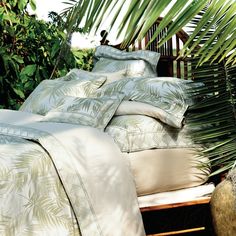 an image of a bed with palm leaves on the sheets and pillowcases in the shade