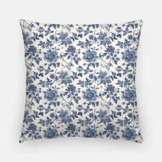 a blue and white floral pillow on a gray background