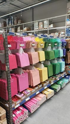 there are many shopping bags on the shelves in this store that is filled with items