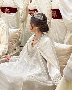 a woman sitting on top of a couch wearing a tiara