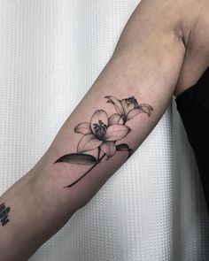 a black and white flower tattoo on the arm