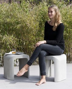 a woman is sitting on a bench outside