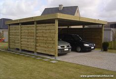 two cars are parked in front of a wooden carport