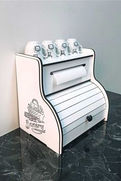 a paper towel dispenser sitting on top of a black marble countertop