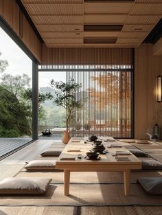 a room that has some pillows on the floor and a table in front of it