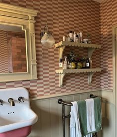 a bathroom with a sink, mirror and towel rack