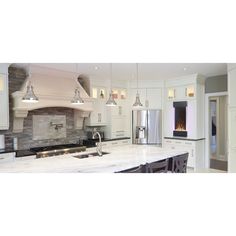 a large kitchen with white cabinets and marble counter tops, along with stainless steel appliances