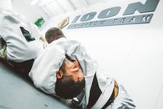 a man laying on the ground with his head down in front of him while wearing a white uniform