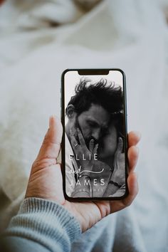 a person holding up a cell phone with a photo on the screen that reads lie lay james