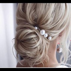 a woman with blonde hair and pearls in her hair