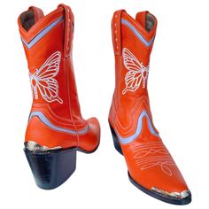 Orange leather with lavender accents, white embroidered butterfly and studded side pulls   22cm cowboy style ankle  Metal accents on toe and heel 6cm wooden heel  Leather sole with rubber attachment  Fit is true to size, if you are a half size we recommend sizing up. Please note: due to all product being handmade each Leather Boots For Western-themed Summer Events, Painted Cowboy Boots, Biker Chick Outfit, Brooklyn Fashion, Ruby Red Slippers, Brooklyn Style, Festival Shoes, Embroidered Butterfly, Deep Winter