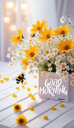 a vase filled with yellow and white flowers on top of a table next to a bee