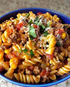 a blue bowl filled with pasta and meat