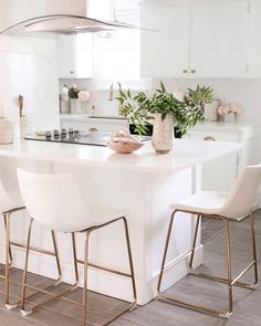 a kitchen with white counter tops and chairs