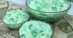 three glass bowls filled with green food on top of a table next to another bowl