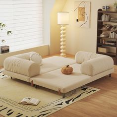 a living room with two white couches and a book shelf on the wall next to it