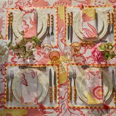 a table set with place settings and flowers