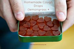 a person holding a tin with hearts in it and the words, homemade cough drops lemongrass + ginger