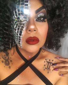 a close up of a person with makeup and accessories on her face, wearing a bra