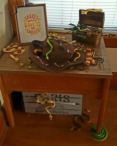 a wooden table topped with lots of assorted items next to a sign and window