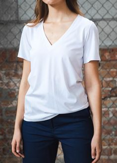 Is there anything more essential than a clean white T? Our deep V-neck t-shirt is beautifully constructed to fit effortlessly and drape over the body the way a t-shirt should. With a trim/relaxed fit through the body and sleeves, our favorite t-shirt will never let you down. White, v-neck, short sleeves. Trim but conformable fit. Slight stretch. Viscose Rayon 66%, Nylon 28%, PU 6%. Made in the USA. Model is wearing XS. Need help with sizing? Size Guide Stretch V-neck T-shirt For Work, Relaxed Fit V-neck T-shirt For Work, White Short Sleeve V-neck Top For Everyday, White V-neck Short Sleeve Top, Versatile Short Sleeve V-neck Top, Viscose Rayon, Let You Down, Deep V Neck, White T