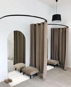 a room with mirrors, stools and curtains on the floor in front of them