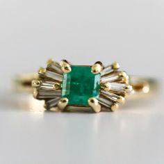 Vintage Ladies 14 Karat Yellow Gold Diamond And Natural Emerald Ring Containing One Square Cut Emerald Measuring 4.65 X 4.59 And Weighing .70 Carats The Emerald Is Described As Light Color And Included With Good Cut And Polish. The Emerald Has A Large Chip On The Girdle Which Extends Into The Crown. Prong Set On Each Side Of The Emerald Are Five Tapered Baguette Shaped Diamonds. Total Weight Of The Ten Tapered Baguettes Is .26 Carats. Diamonds Are Graded H-I In Color And Vs Clarity. Overal Weigh Emerald Cocktail Ring, Emerald Cocktail, Natural Emerald Rings, Square Cut, Natural Emerald, Emerald Ring, Womens Jewelry Rings, Cocktail Rings, Prong Setting