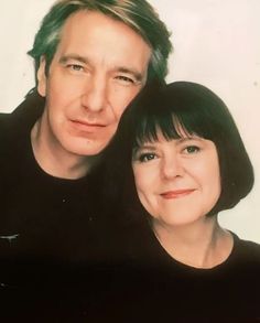 a man and woman are posing for a photo in front of a white background together