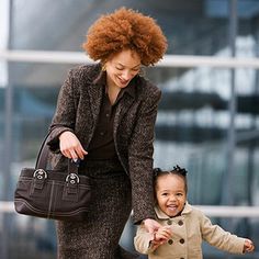 a woman holding the hand of a small child