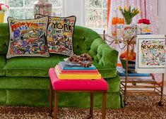 a living room filled with green couches and colorful pillows on top of each other