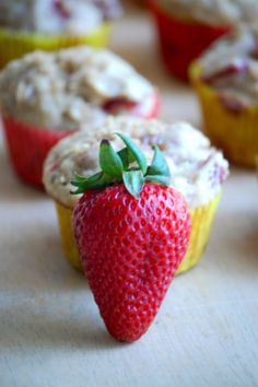 some cupcakes with strawberries and cream on them