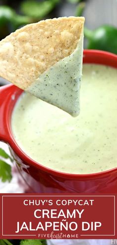 a tortilla chip being dipped into a bowl of creamy jalapeno dip