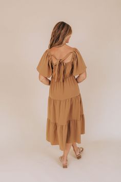 Make a stylish statement in the See You Later Dress. This light brown midi dress features flutter sleeves and charming crochet details on the bodice, adding a playful touch to your look. The tie back, elastic waistband, and functional pockets provide a comfortable and practical fit. Perfect for any occasion, this dress is sure to turn heads! Details Light brown dress with crochet details on bodice Tie in back Flutter sleeves Midi length Tiered skirt Elastic waistband and sleeve tops Functional p Beige Tie-back Midi Dress For Brunch, Beige Tie Back Midi Dress For Brunch, Casual Flutter Sleeve Midi Dress For Brunch, Casual Midi Dress With Flutter Sleeves For Brunch, Brown Smocked Back Dress For Vacation, Brown Smocked Back Dress For Brunch, Beige Tie-back Midi Dress For Day Out, Beige Tie Back Midi Dress For Day Out, Brown Vacation Dress With Smocked Back