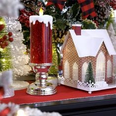 a lit candle is sitting on a table next to some christmas trees and other decorations