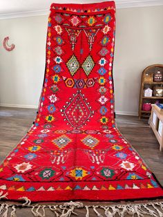 a large red rug is on display in a room