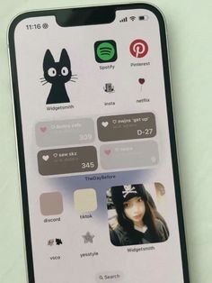 an iphone screen with icons on it and a cat sticker above the phone's keyboard