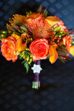 a bridal bouquet with orange and yellow flowers