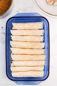 several tortillas stacked on top of each other in a blue dish next to doughnuts