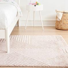 a bedroom with a bed, nightstand and rug in the middle of the floor area