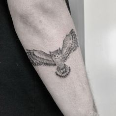 an owl tattoo on the left arm