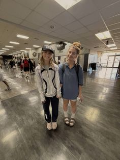 two girls are standing in an empty room with one holding the other's hand