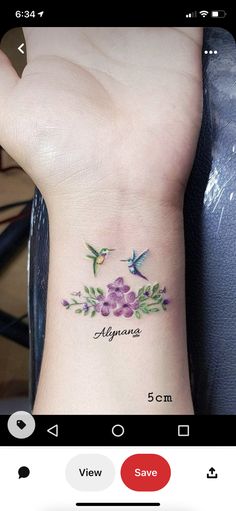 a small wrist tattoo with two hummings and flowers on the left side of the wrist