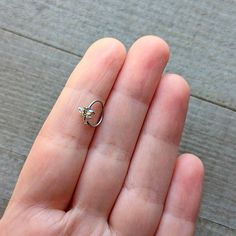 a hand holding a tiny ring on top of it's palm with a flower in the middle