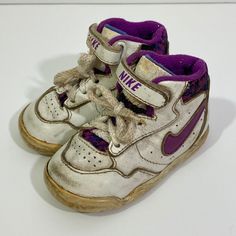 Little kid's vintage 1991 Nike high top sneakers. The shoes have a fabulous 90's color scheme with purple swoosh and purple patterned tongue and back. The shoes have short white laces and a hook and loop strap. They are super rare! I can't seem to find another pair on the internet.  The sneakers are in play condition. There is quite a bit of scuffing, cracking and chipping as pictured.  Size 3.5 5 1/4 inches long Vintage Low-top Basketball Shoes, Vintage White High-top Basketball Shoes, Vintage White Basketball Shoes, Vintage White Skate Shoes With Round Toe, Nike 90s Shoes, Vintage Pink Sneakers With Round Toe, Vintage Pink High-top Sneakers, 90s Nike Shoes, Nike Baby Shoes